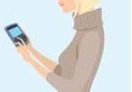 A blonde woman looking at her phone.