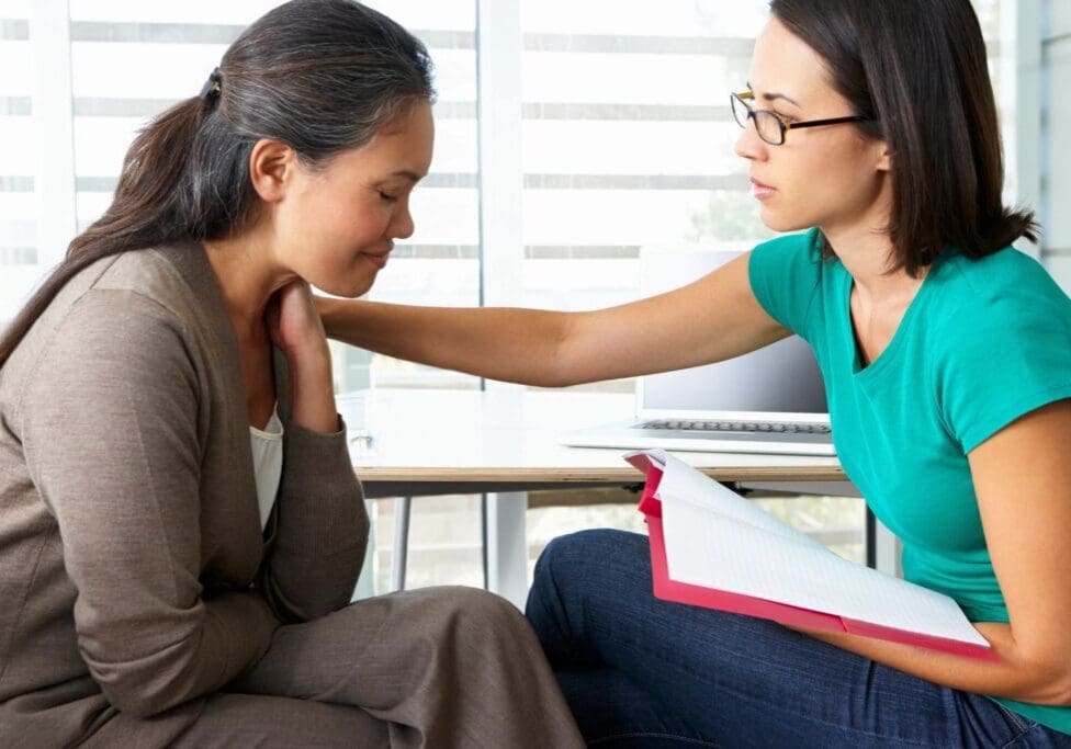 Counselor comforting woman during a session.
